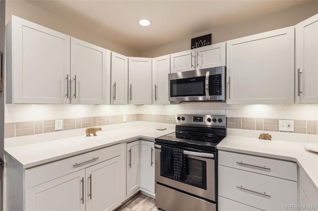 3144 S Wheeling Way Unit 401, Aurora, CO 80014 - kitchen featuring appliances with stainless steel finishes, light countertops, white cabinetry, and recessed lighting