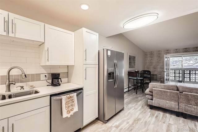 3144 S Wheeling Way Unit 401, Aurora, CO 80014 - kitchen featuring stainless steel appliances, vaulted ceiling, white cabinetry, a sink, and light countertops