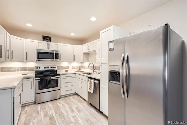 3144 S Wheeling Way Unit 401, Aurora, CO 80014 - kitchen with stainless steel appliances, a sink, decorative backsplash, light countertops, and light wood-style flooring