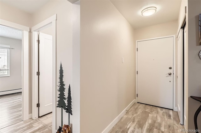3144 S Wheeling Way Unit 401, Aurora, CO 80014 - hallway with light wood-style flooring, a baseboard heating unit, and baseboards