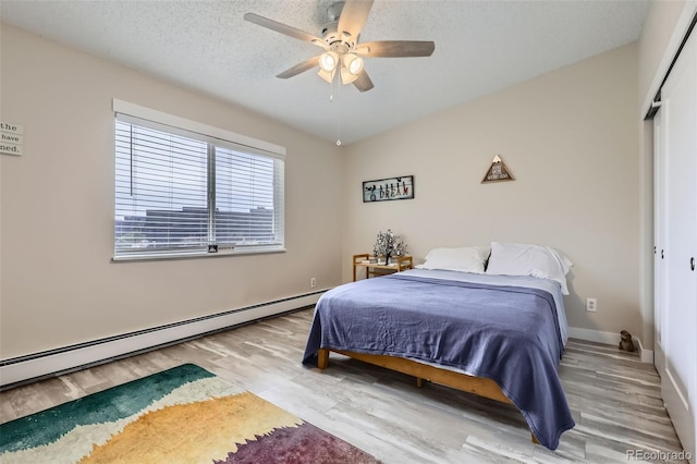 3144 S Wheeling Way Unit 401, Aurora, CO 80014 - bedroom featuring a baseboard radiator, wood finished floors, a closet, ceiling fan, and a textured ceiling