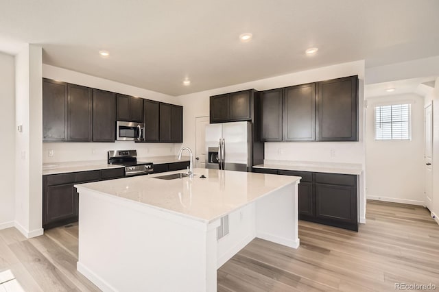 2190 S Haleyville Way, Aurora, CO 80018 - kitchen with appliances with stainless steel finishes, a sink, light wood finished floors, recessed lighting, and a kitchen island with sink