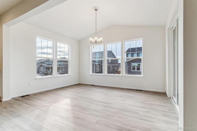 unfurnished dining area featuring a chandelier, vaulted ceiling, and light wood-type flooring