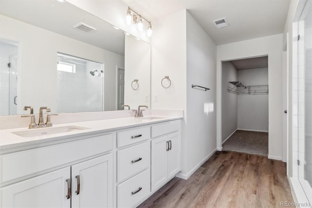 bathroom with vanity, a shower with shower door, and hardwood / wood-style flooring