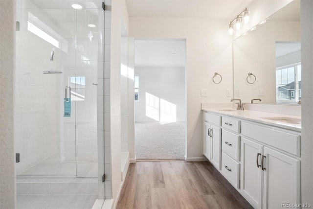 bathroom with wood-type flooring, vanity, and walk in shower