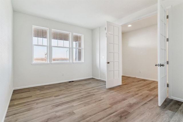 spare room with light hardwood / wood-style flooring