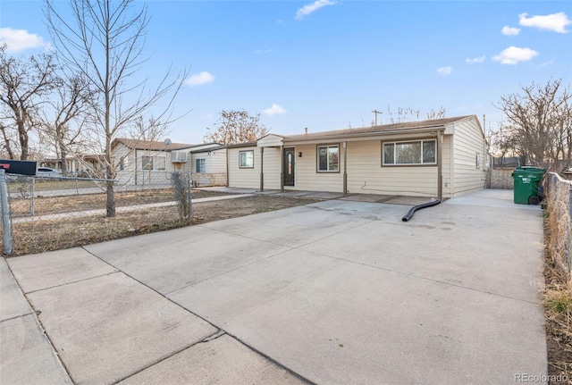 ranch-style home with fence and concrete driveway