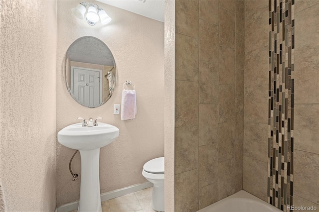 bathroom with baseboards, a sink, toilet, and tile patterned floors