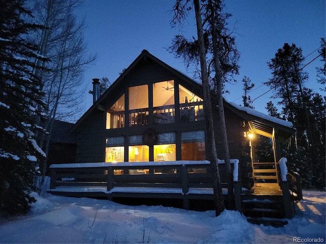 view of snow covered back of property