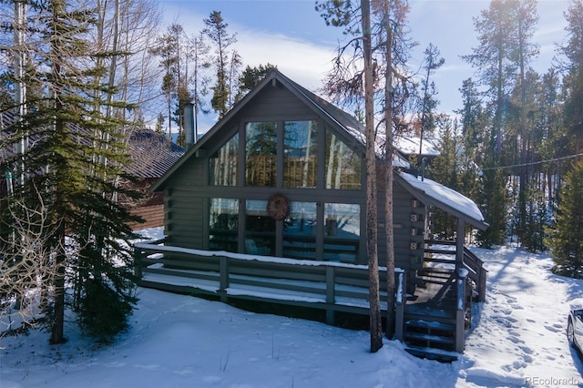 view of snow covered back of property