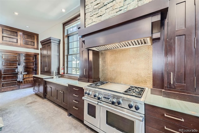 kitchen featuring double oven range, light countertops, dark brown cabinetry, and recessed lighting
