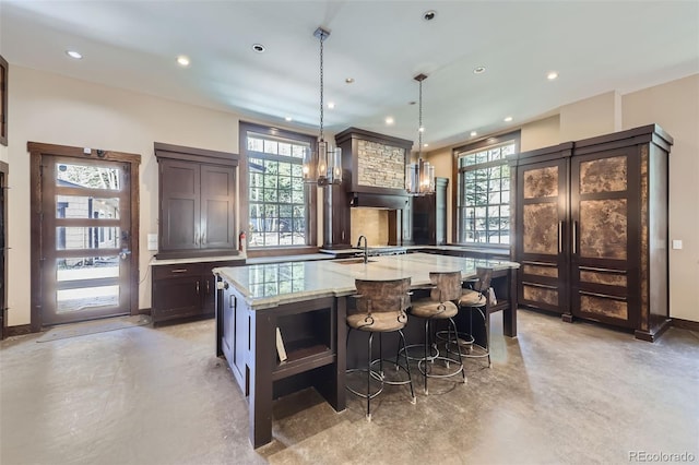 bar featuring finished concrete floors, a sink, recessed lighting, pendant lighting, and baseboards