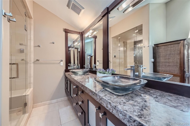 full bathroom with a stall shower, tile patterned flooring, double vanity, lofted ceiling, and baseboards