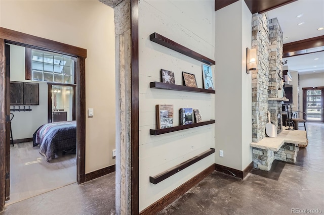 hall with concrete flooring, baseboards, and recessed lighting
