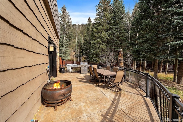 2971 Fall River Rd, Idaho Springs, CO 80452 - view of patio with outdoor dining space, an outdoor fire pit, and a wooded view