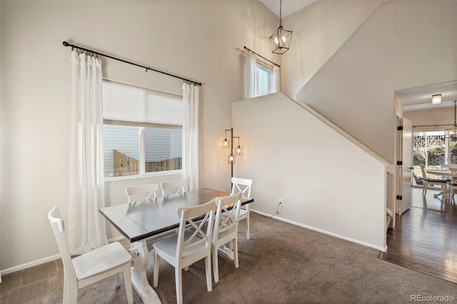 dining space featuring dark carpet, plenty of natural light, and a notable chandelier