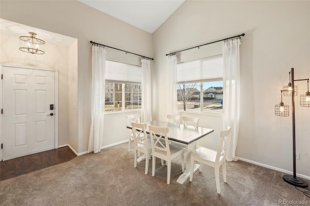 carpeted dining area with lofted ceiling, a chandelier, and baseboards