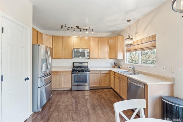 kitchen with a sink, light countertops, appliances with stainless steel finishes, light brown cabinetry, and decorative light fixtures