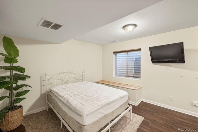 bedroom featuring visible vents, dark wood finished floors, and baseboards