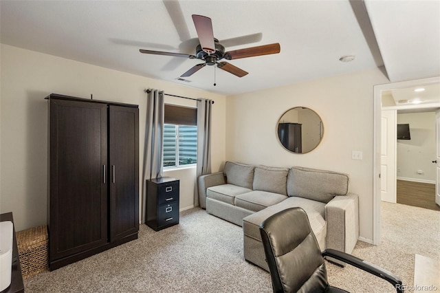 living area featuring a ceiling fan, light carpet, visible vents, and baseboards