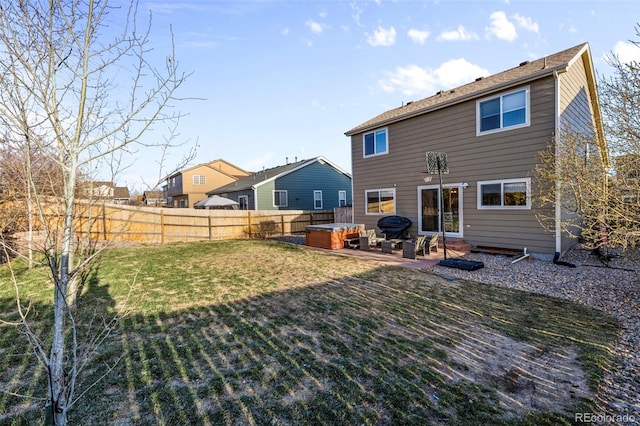 back of house featuring a patio area, a hot tub, a fenced backyard, and a yard