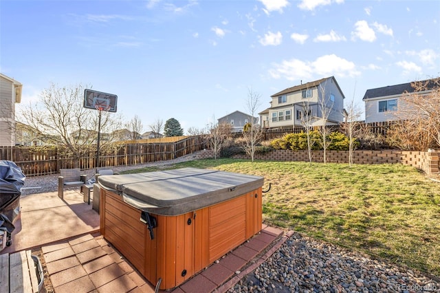 view of yard featuring a hot tub, a fenced backyard, and a patio