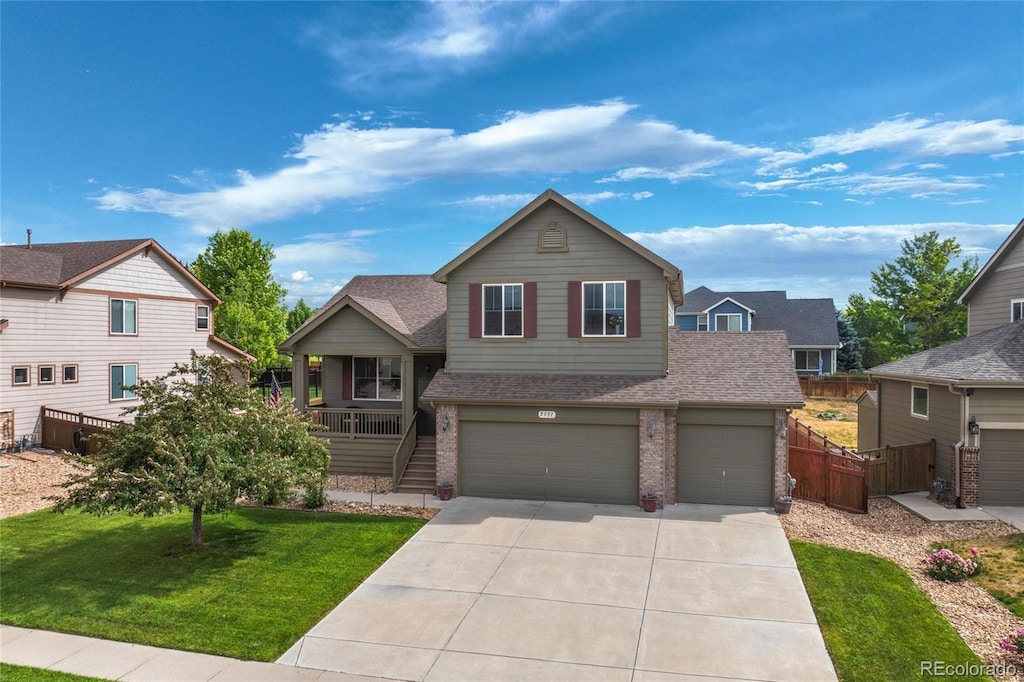 view of front of property featuring a garage, a front lawn, and a porch