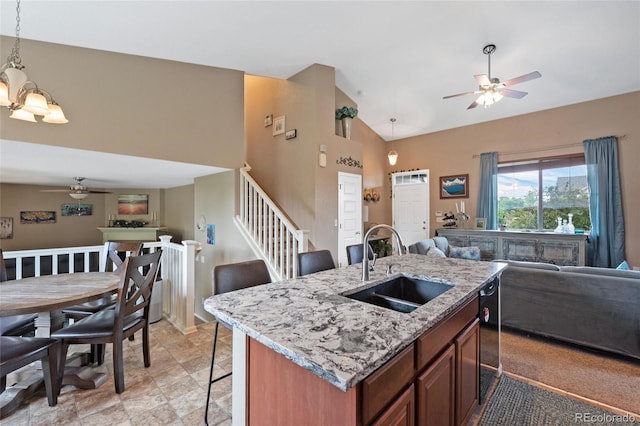 kitchen with sink, a breakfast bar area, an island with sink, pendant lighting, and ceiling fan