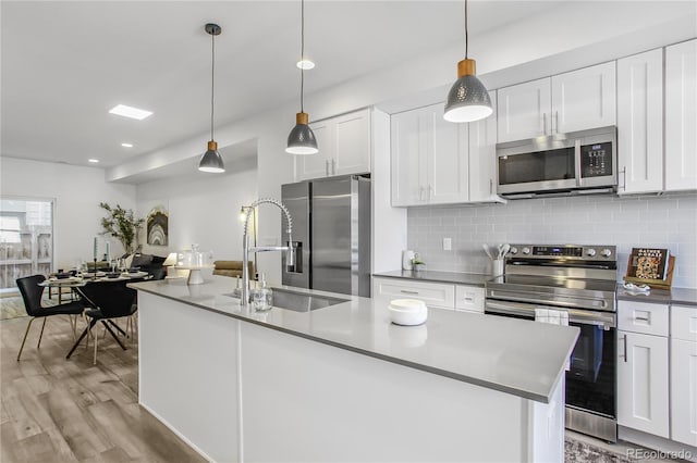 kitchen featuring a sink, decorative backsplash, appliances with stainless steel finishes, and white cabinets