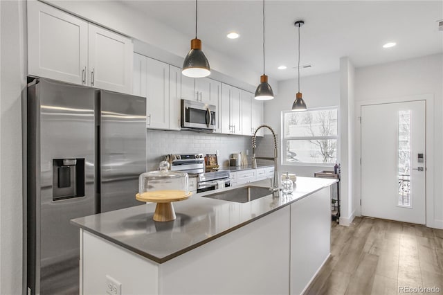 kitchen featuring a sink, stainless steel appliances, white cabinets, and decorative backsplash