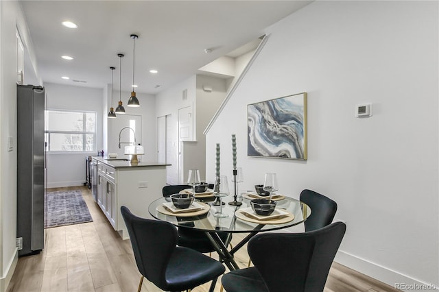 dining area with recessed lighting, light wood-style floors, and baseboards