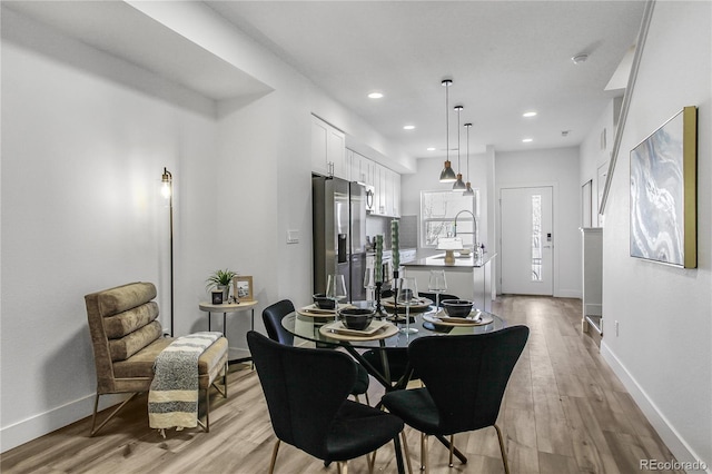 dining space with recessed lighting, baseboards, and light wood-type flooring