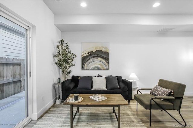 living area with recessed lighting, visible vents, baseboards, and wood finished floors