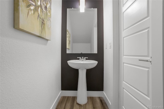 bathroom with baseboards and wood finished floors