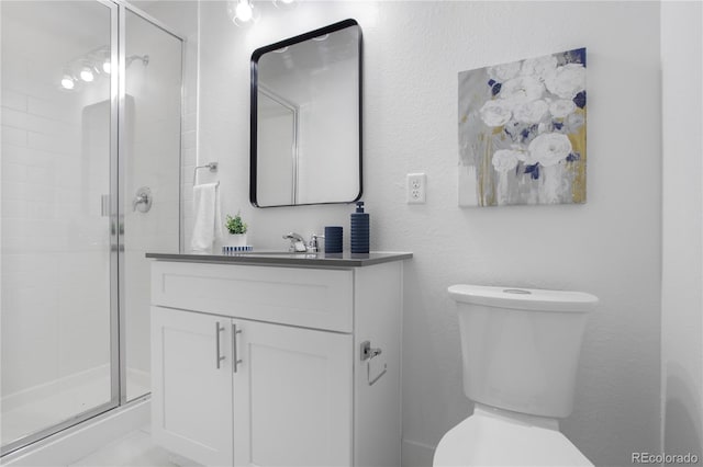 bathroom with vanity, toilet, and a stall shower