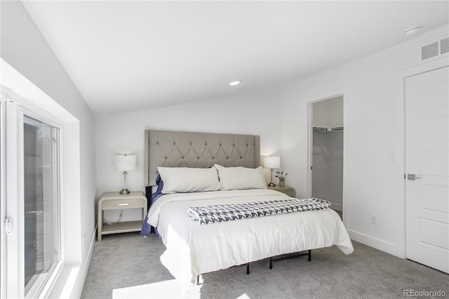 carpeted bedroom featuring lofted ceiling, a spacious closet, baseboards, and visible vents