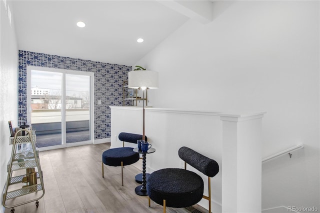 sitting room with wood finished floors, baseboards, wallpapered walls, lofted ceiling with beams, and recessed lighting