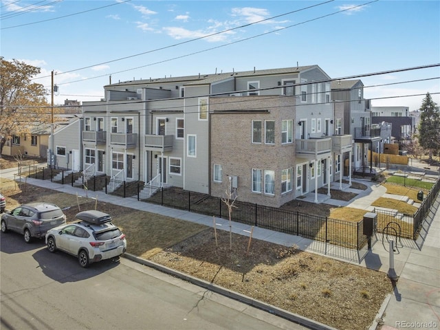 view of front of home featuring a fenced front yard, a residential view, and a balcony