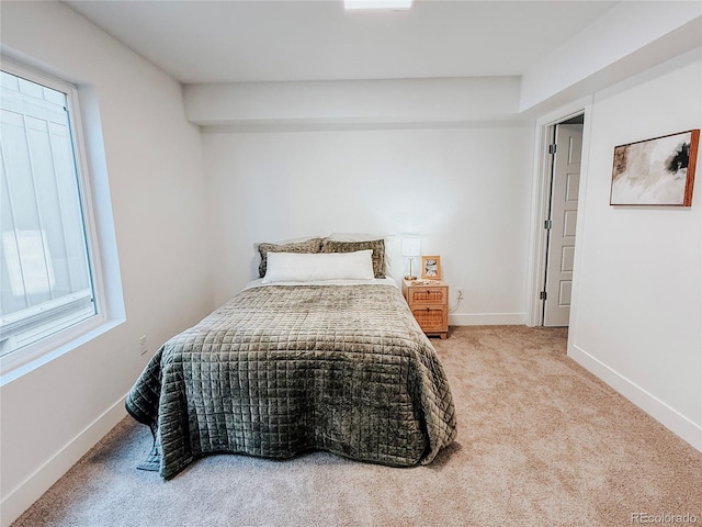 carpeted bedroom featuring baseboards and multiple windows