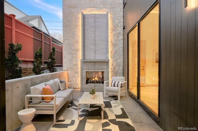 balcony with a patio and an outdoor living space with a fireplace