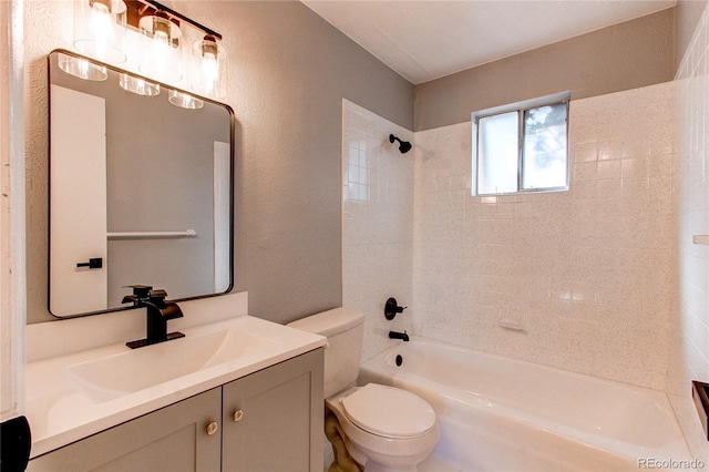 full bathroom featuring tiled shower / bath combo, vanity, and toilet