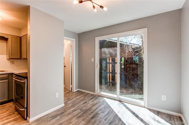 kitchen featuring light wood-type flooring, stainless steel range, and tasteful backsplash