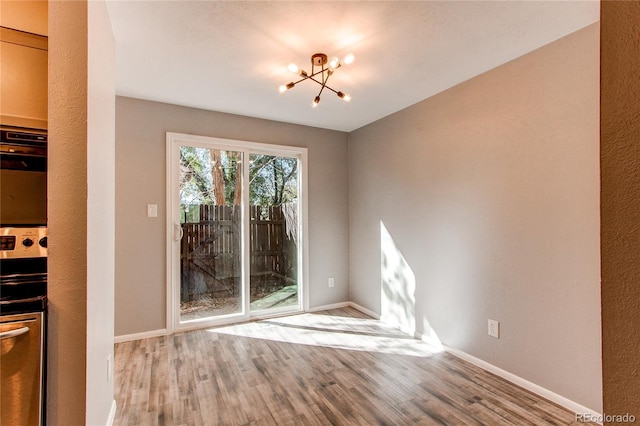 unfurnished dining area featuring a chandelier and light hardwood / wood-style floors