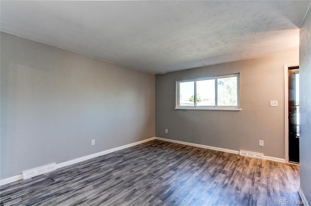 empty room with dark hardwood / wood-style flooring