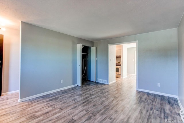 empty room featuring wood-type flooring and a textured ceiling