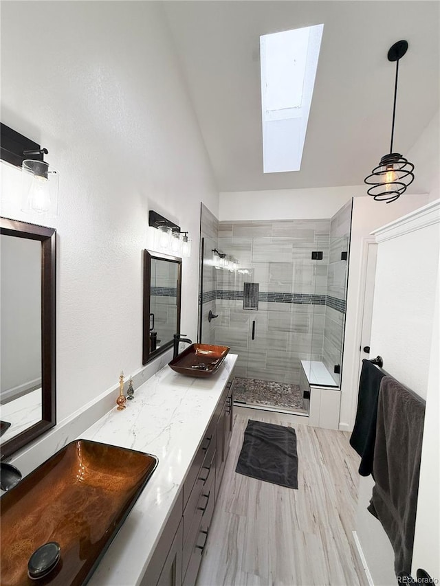 bathroom with hardwood / wood-style floors, vanity, an enclosed shower, and lofted ceiling with skylight