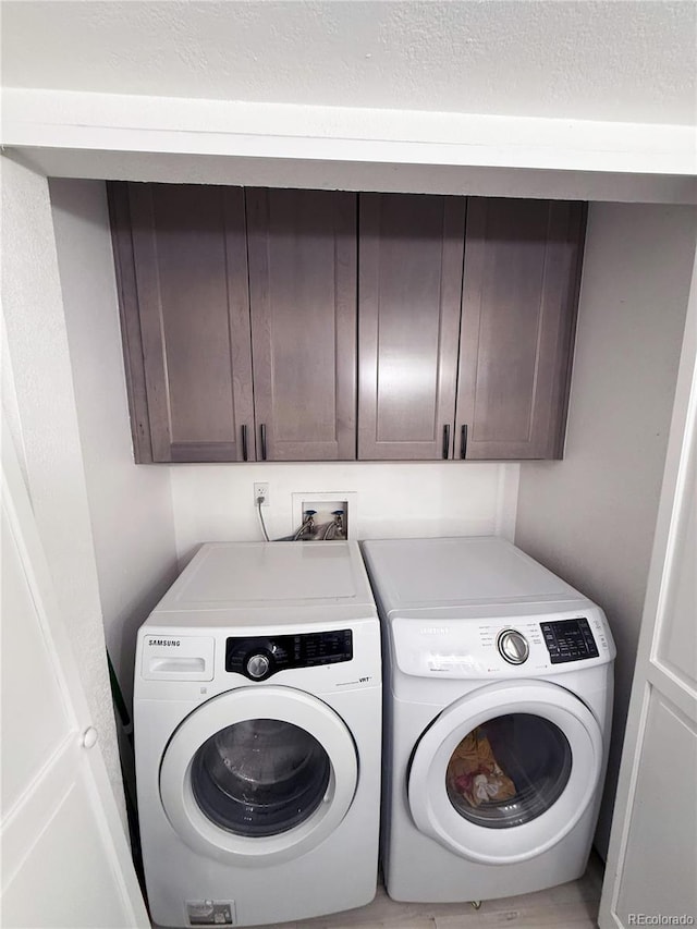 laundry area featuring cabinets and washer and clothes dryer