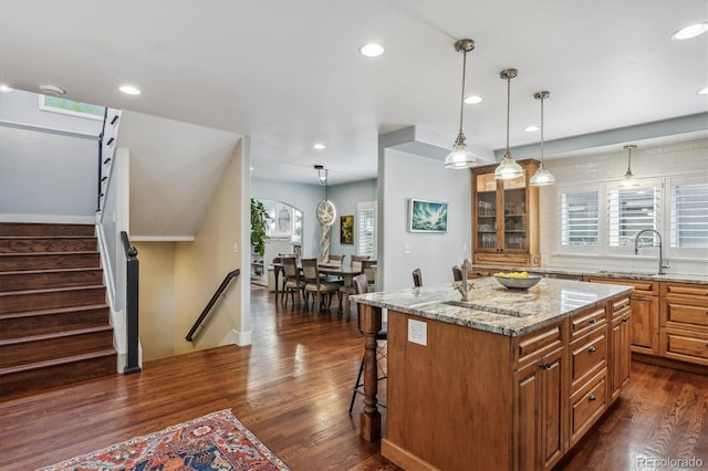 kitchen featuring a wealth of natural light, dark wood-style flooring, and a kitchen bar