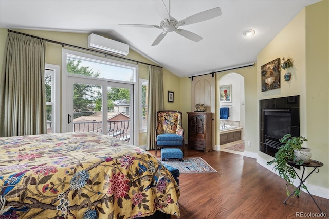 bedroom with access to exterior, arched walkways, lofted ceiling, an AC wall unit, and wood finished floors