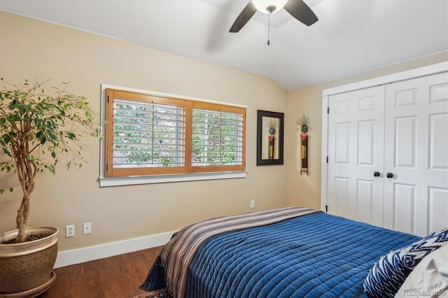 bedroom with a closet, ceiling fan, vaulted ceiling, wood finished floors, and baseboards